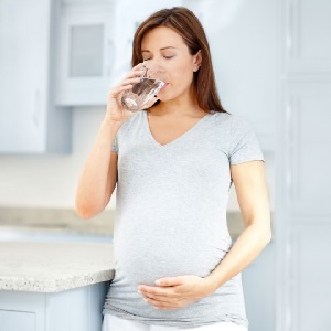 Беременная женщина пьет воду